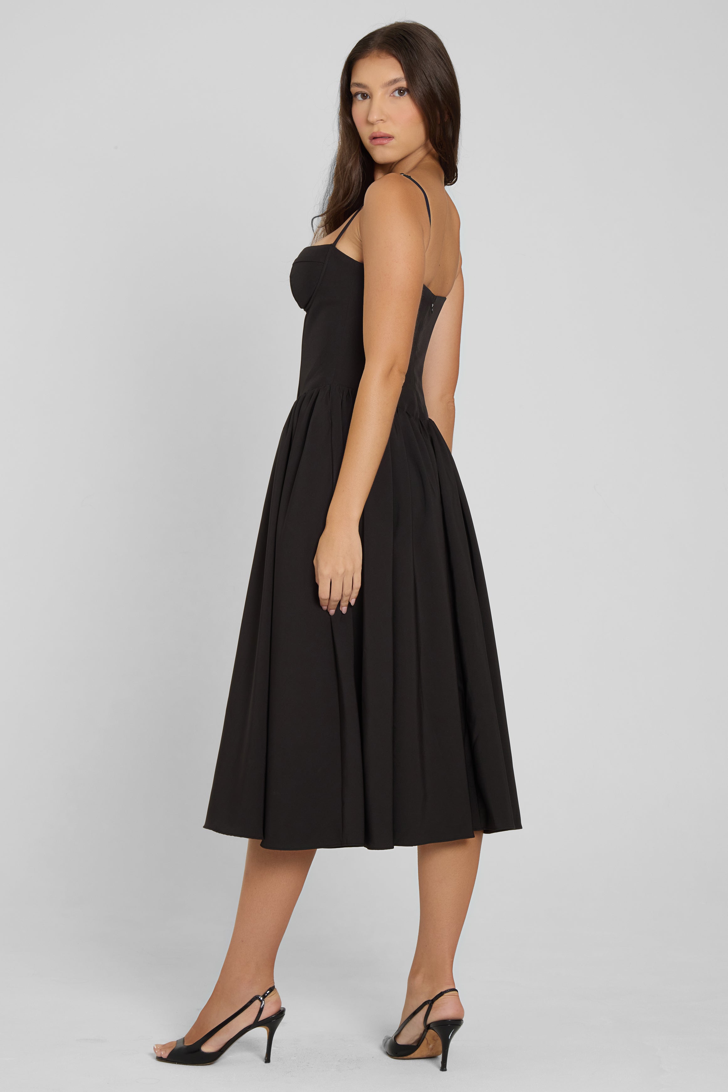 Model wearing Ballerina Bustier Midi Dress in Black, side view.