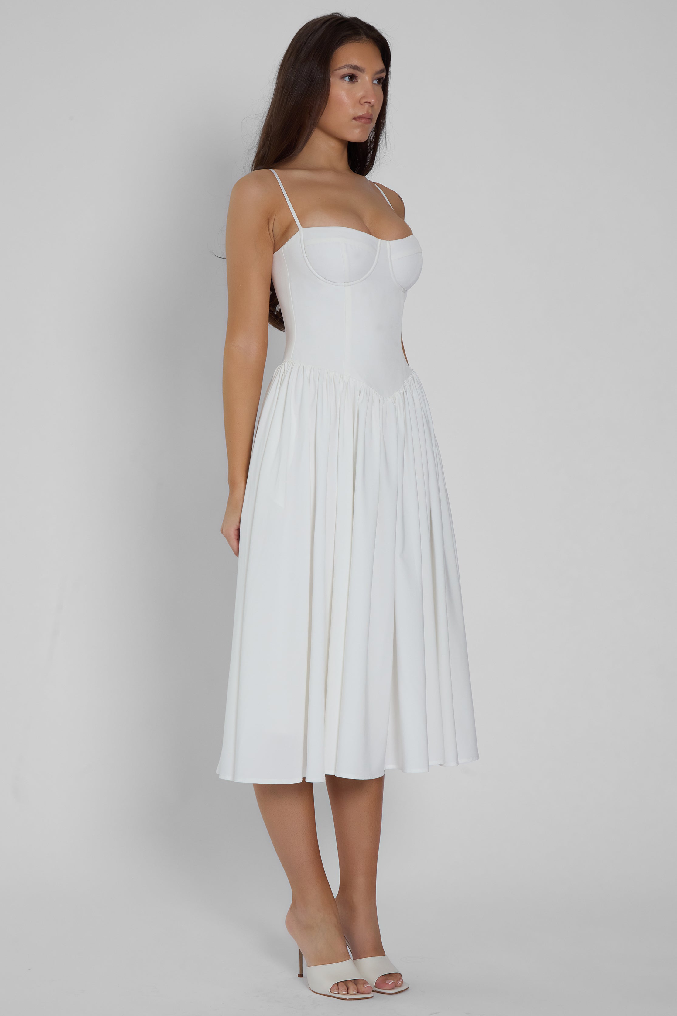 Model wearing Ballerina Bustier Midi Dress in White, side view.