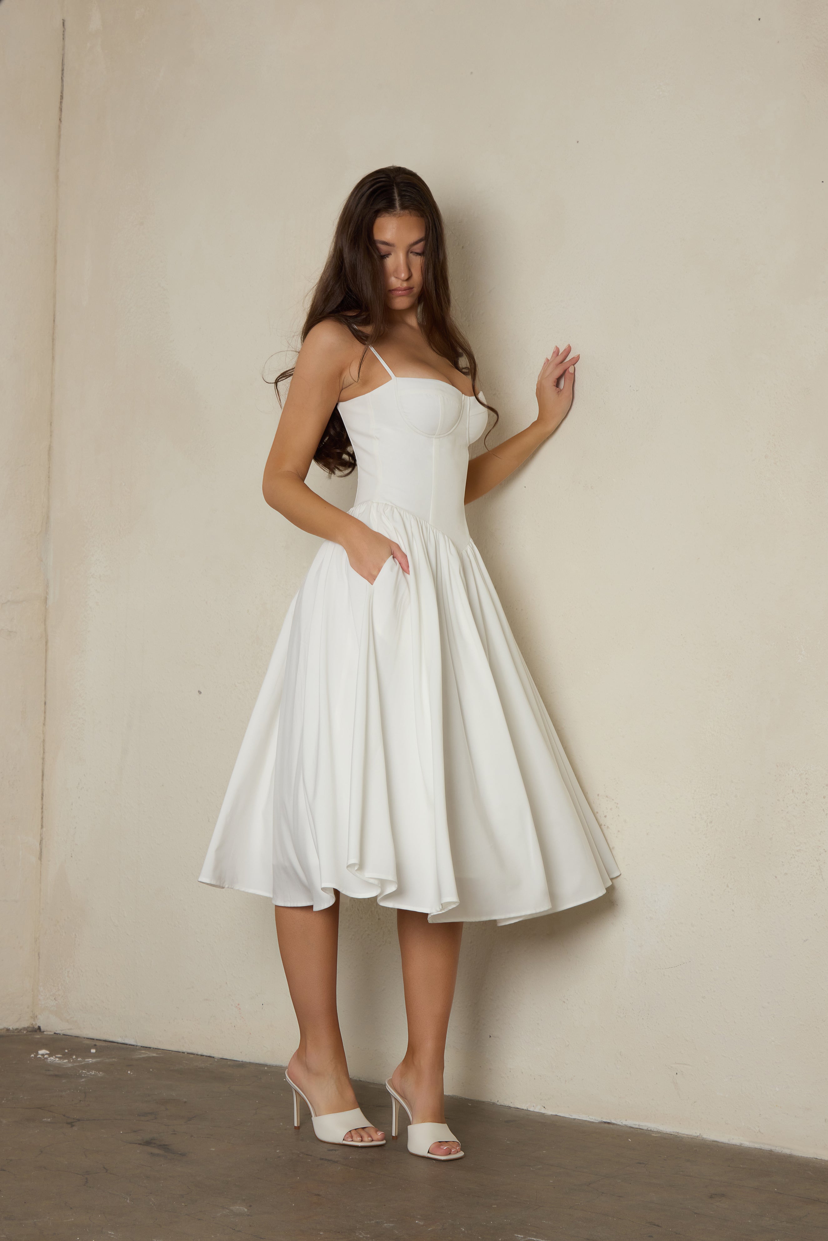 Model wearing Ballerina Bustier Midi Dress in White, side view.