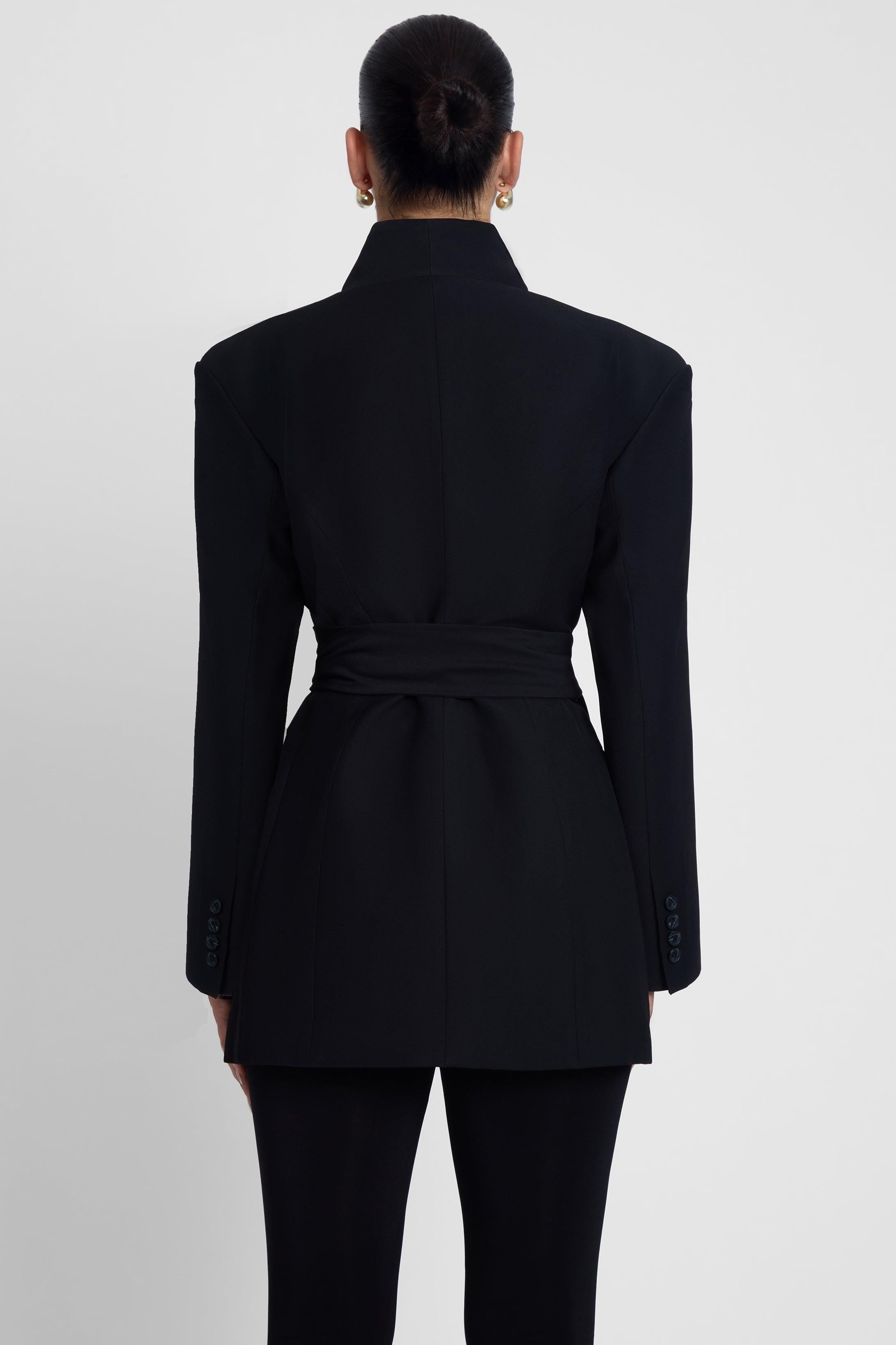 Model is wearing Cairo Hourglass Belted Coat Black, back view.