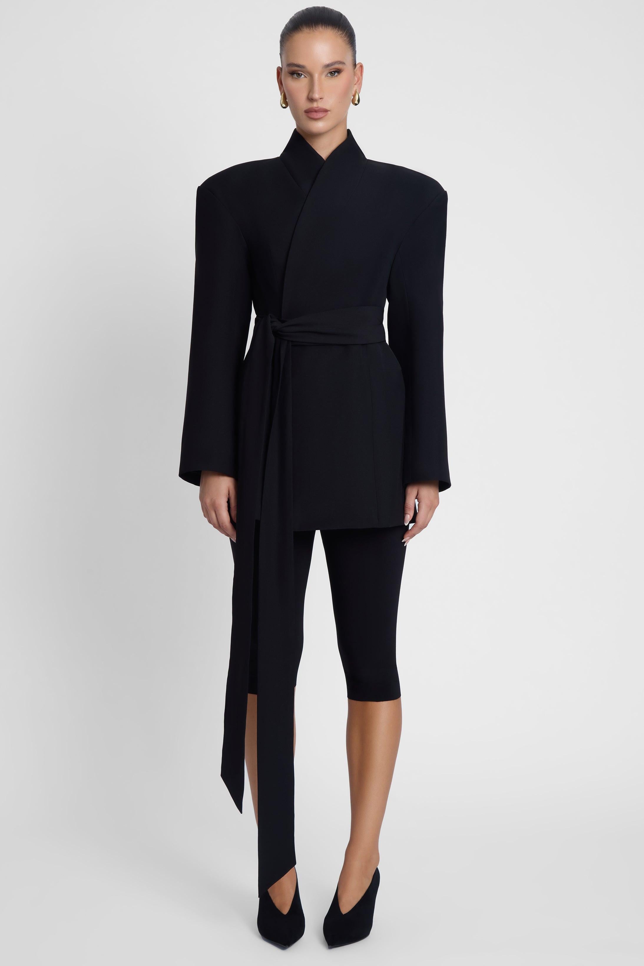 Model is wearing Cairo Hourglass Belted Coat Black, front view.