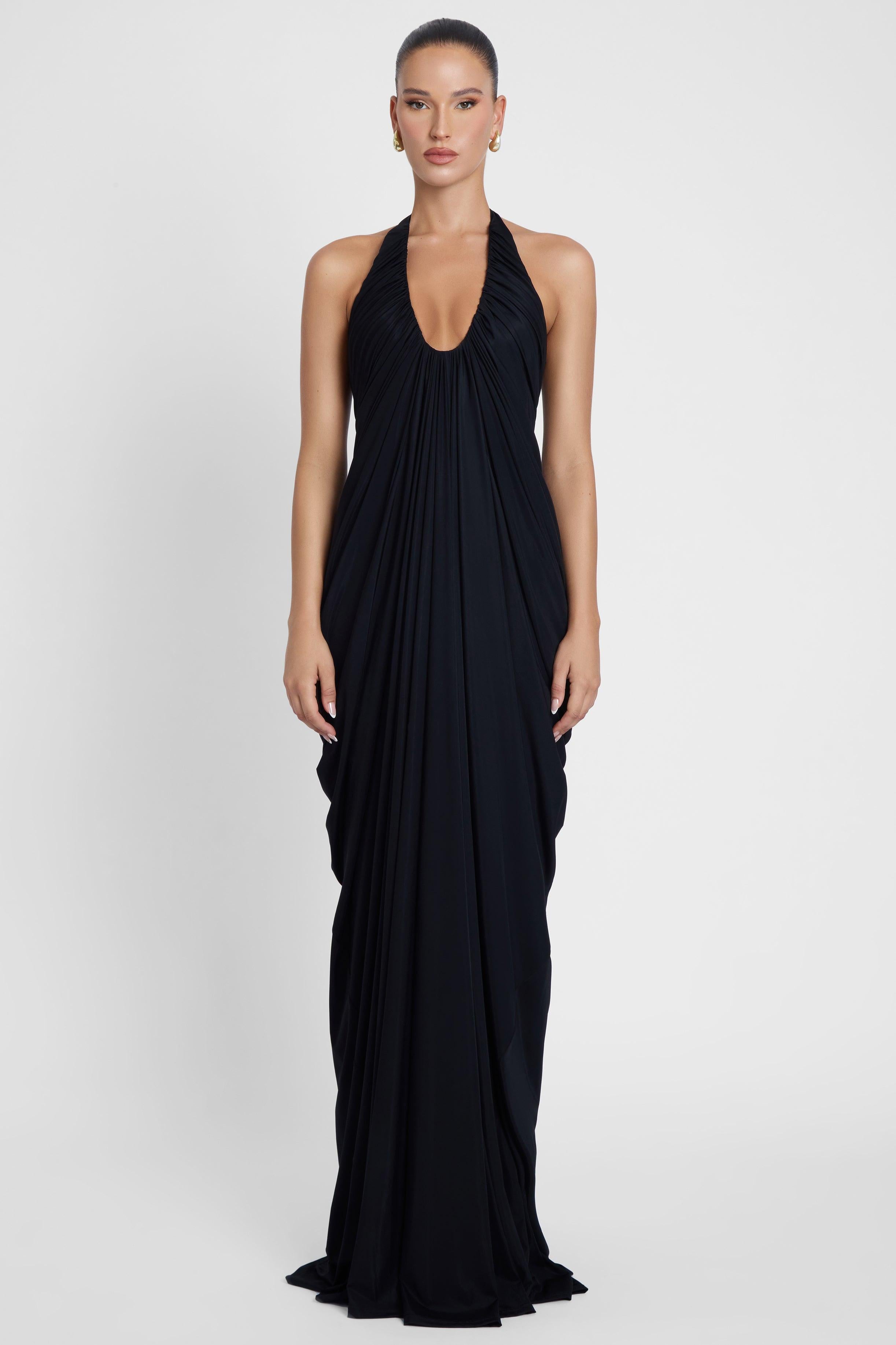 Model is wearing Cascade Drape Gown Black in Black, front view.