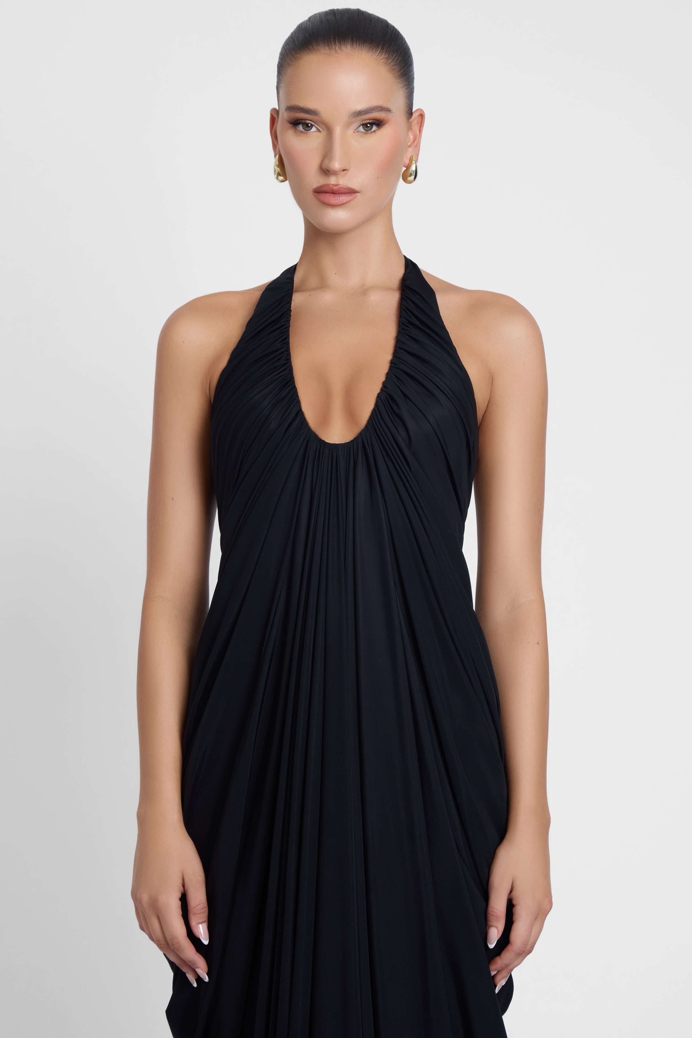 Model is wearing Cascade Drape Gown Black in Black, front view.