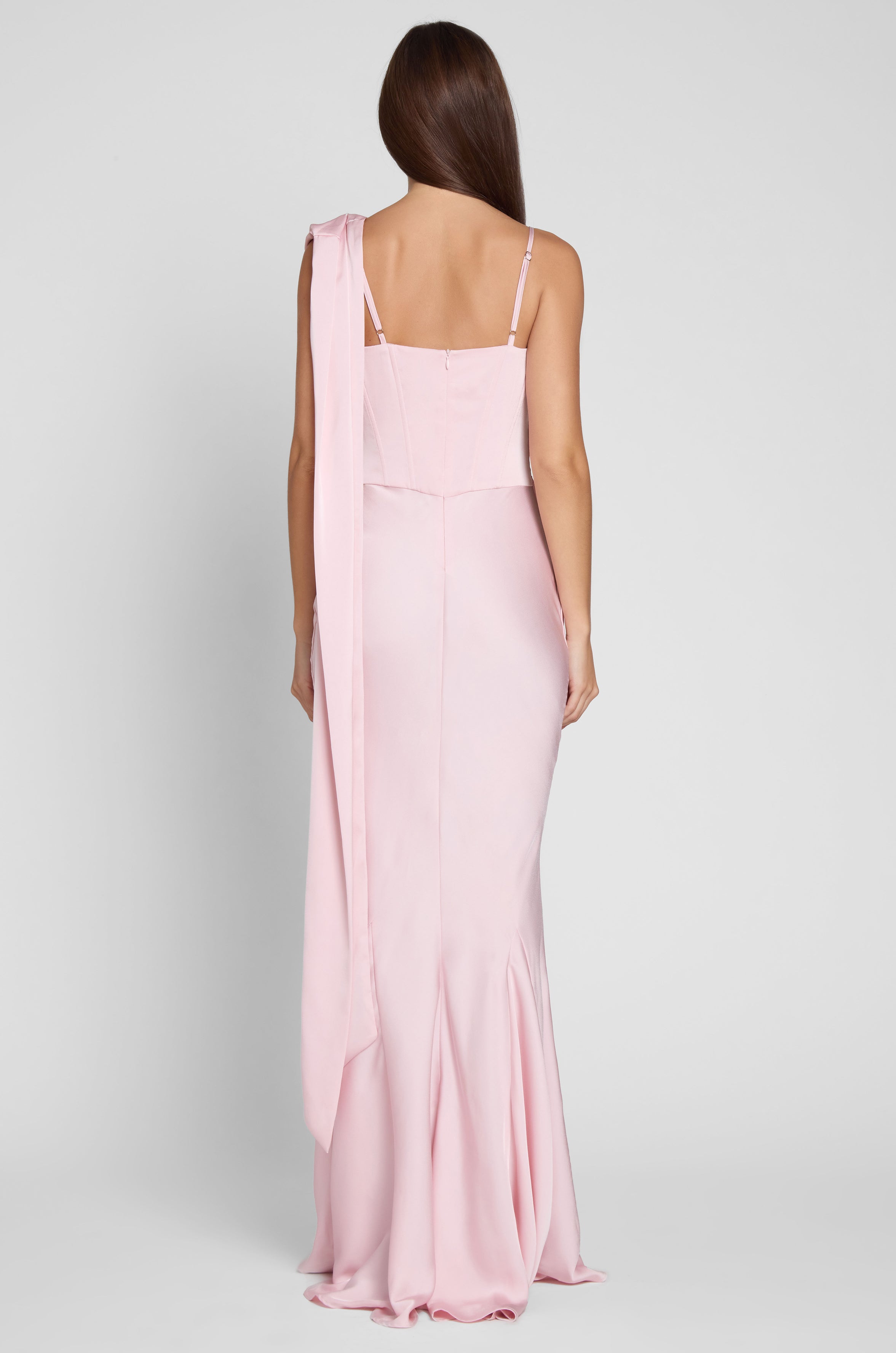Model is wearing Celine Corset Drape Satin Gown in Pink, back view.
