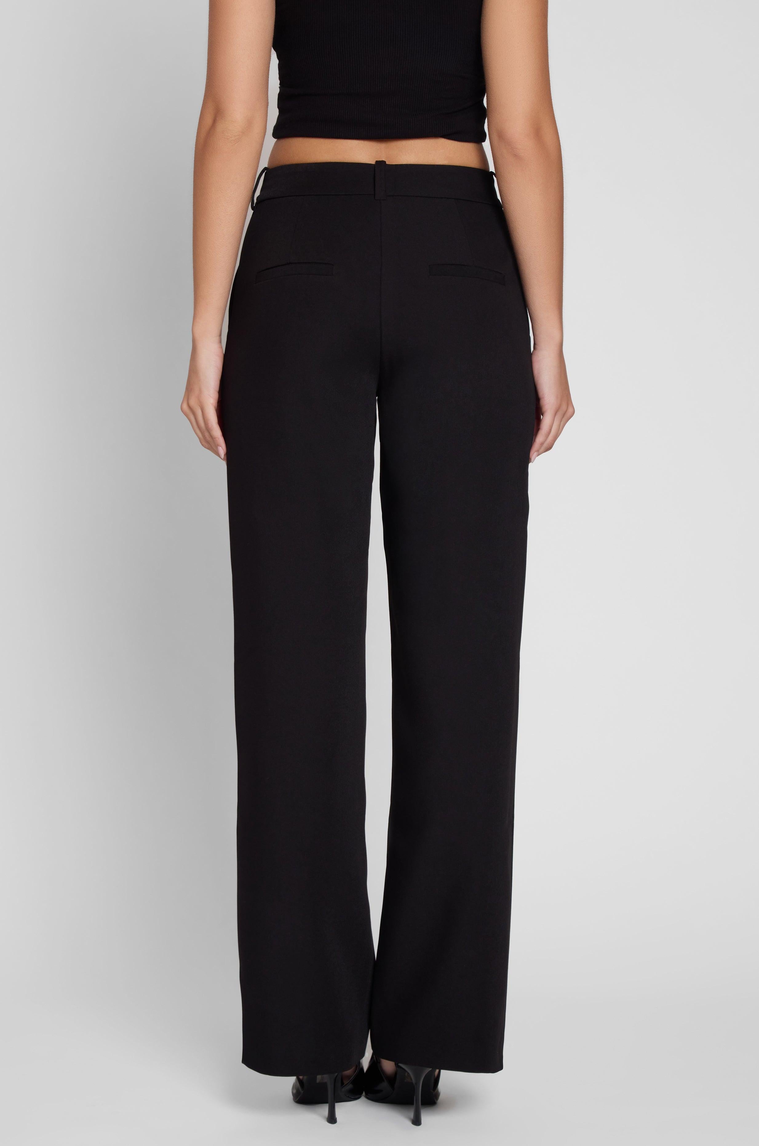 Model is wearing Classic Column Straight Trousers in Black, back view.