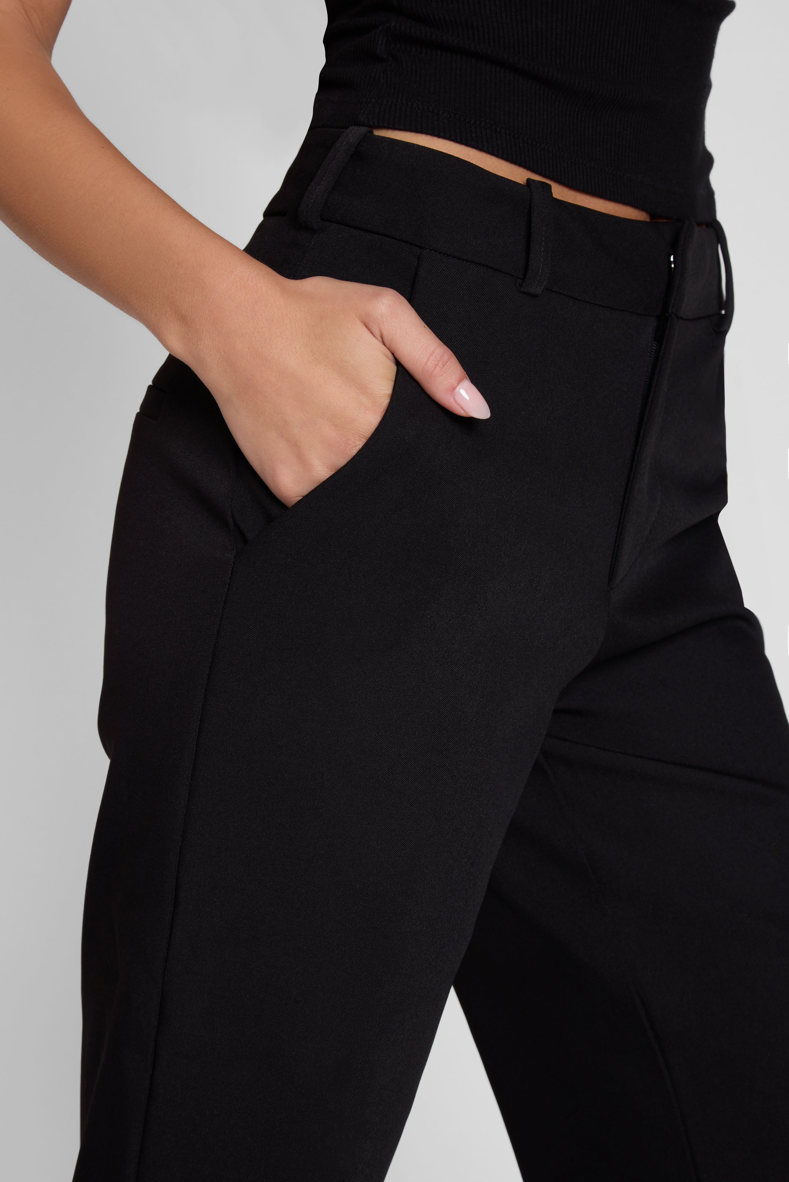 Model is wearing Classic Column Straight Trousers in Black, side view.