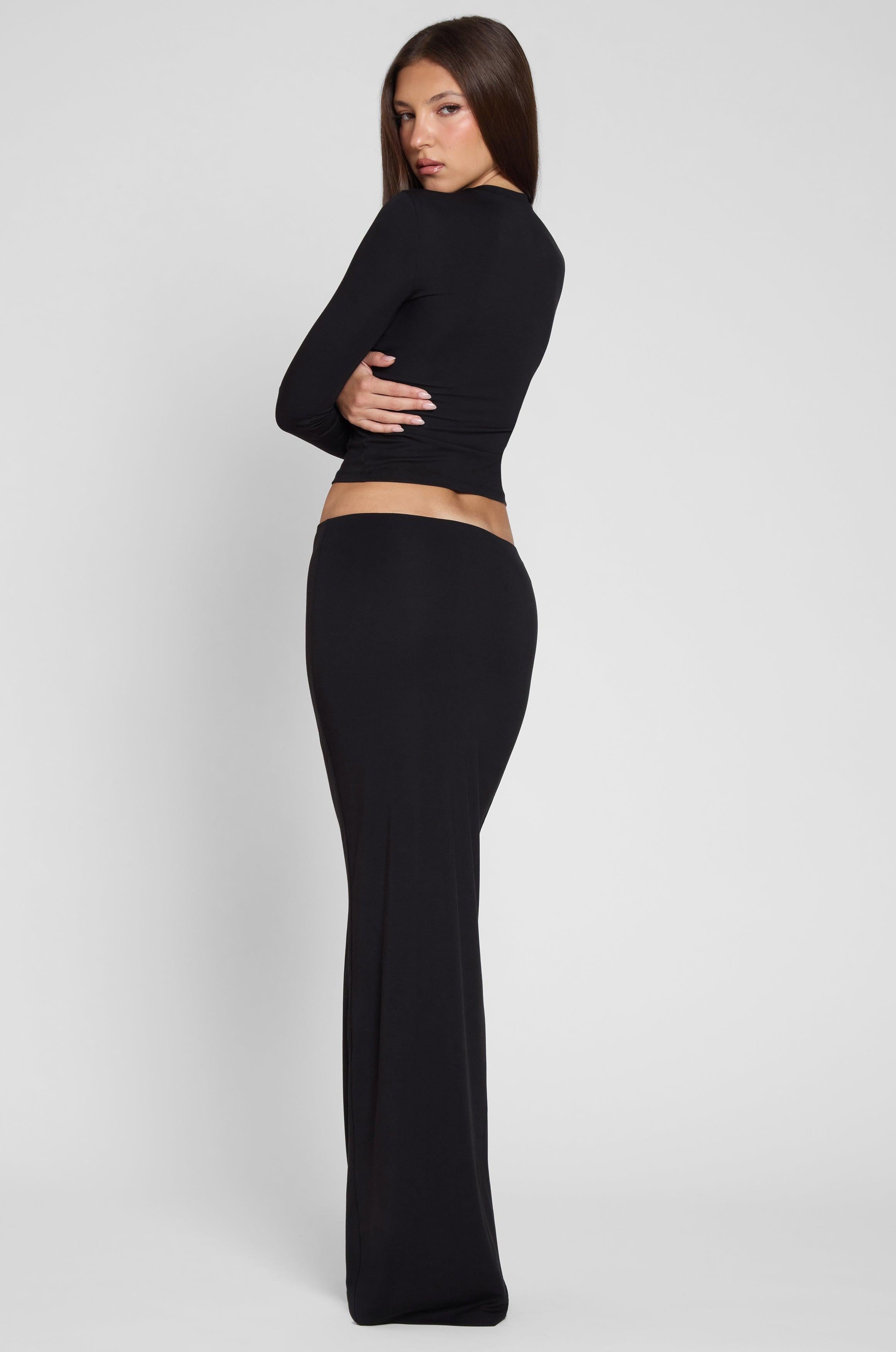 Model is wearing Everyday Jersey Maxi Skirt in Black, back view.