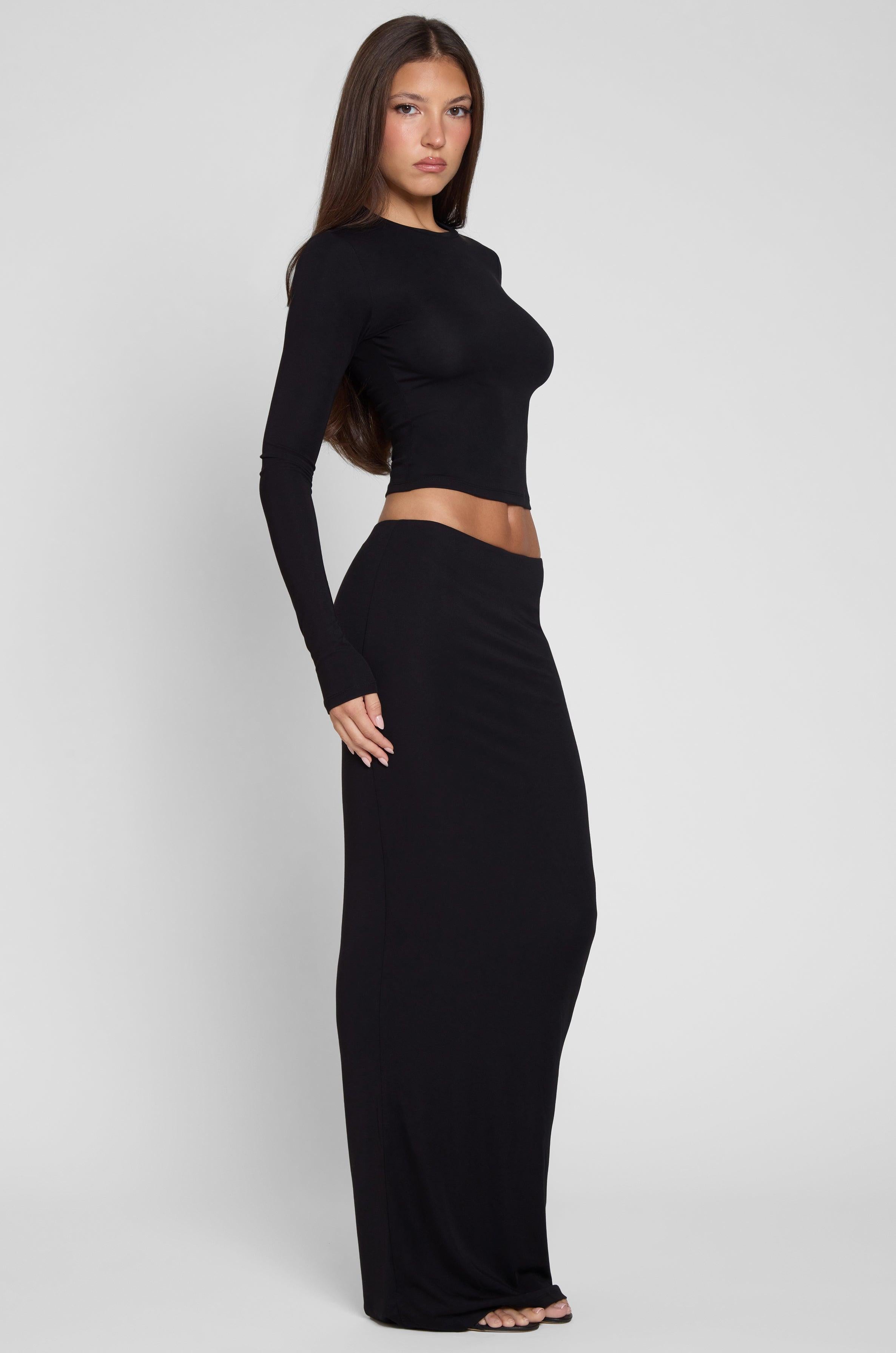 Model is wearing Everyday Jersey Maxi Skirt in Black, side view.