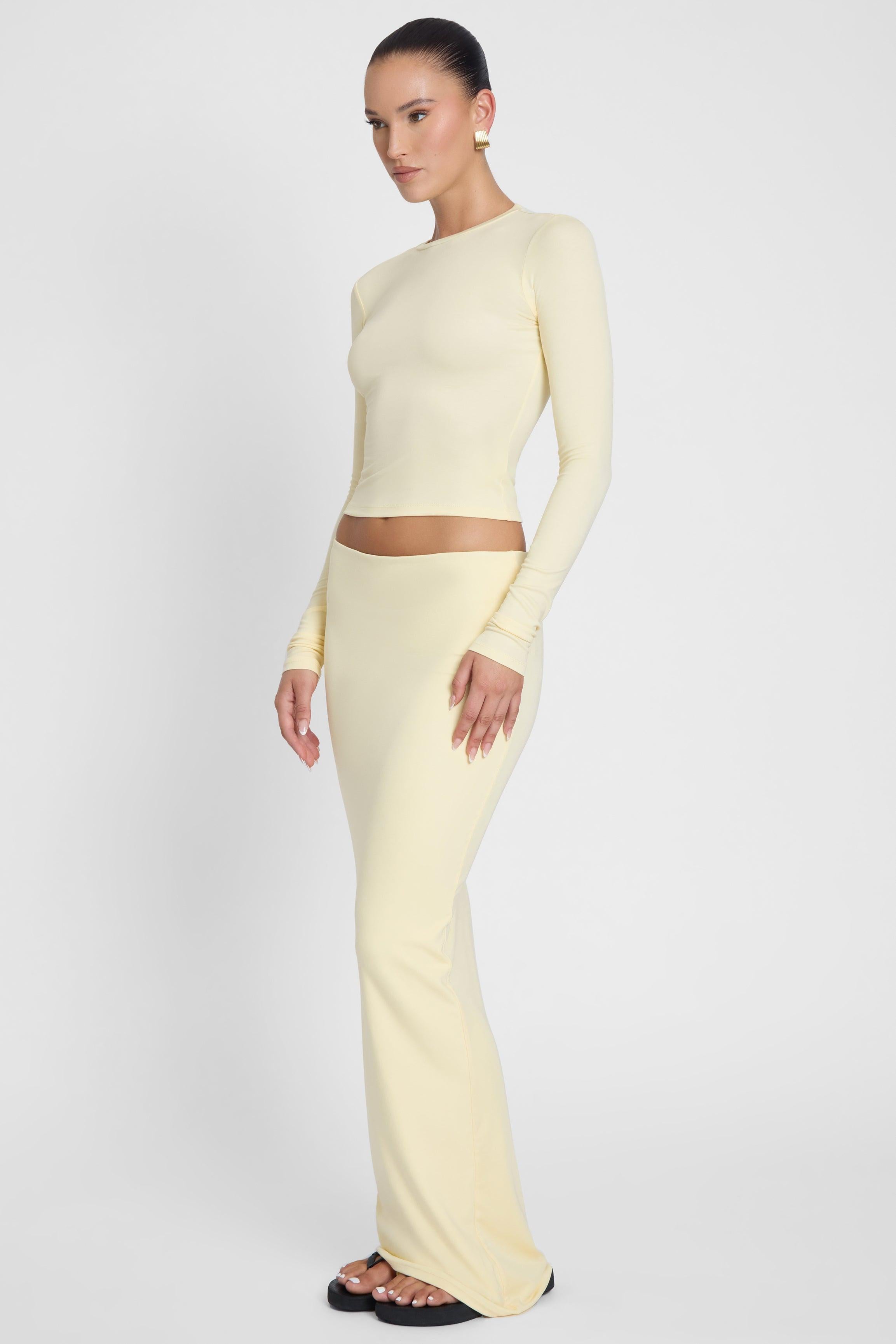 Model is wearing Everyday Jersey Maxi Skirt Yellow, side view.