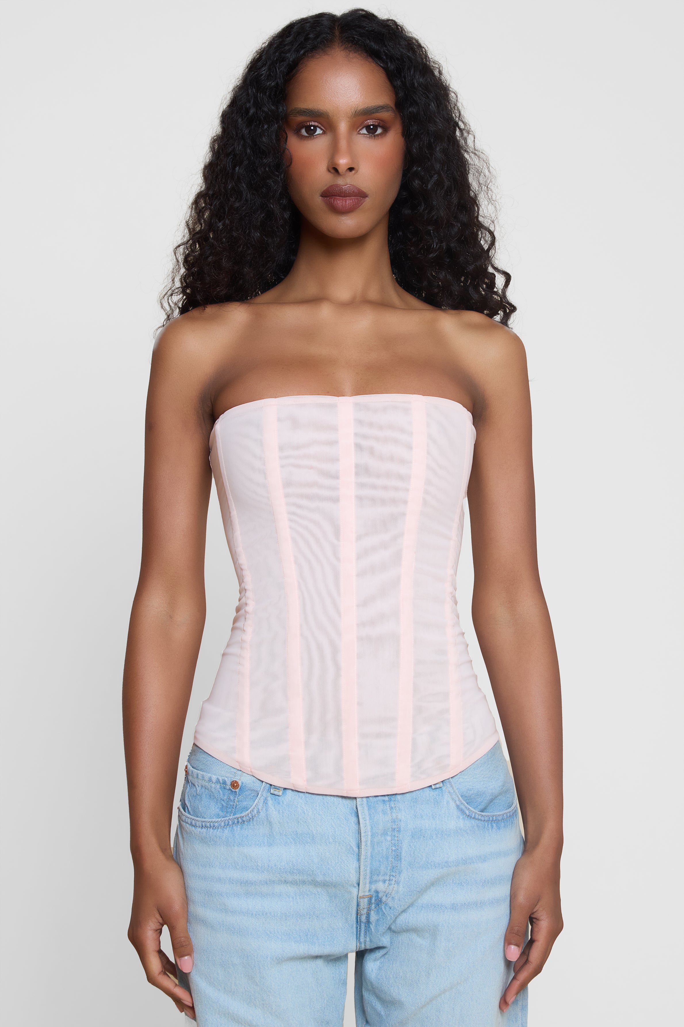 Model wearing Muse Mesh Corset Top in Pink, front view.