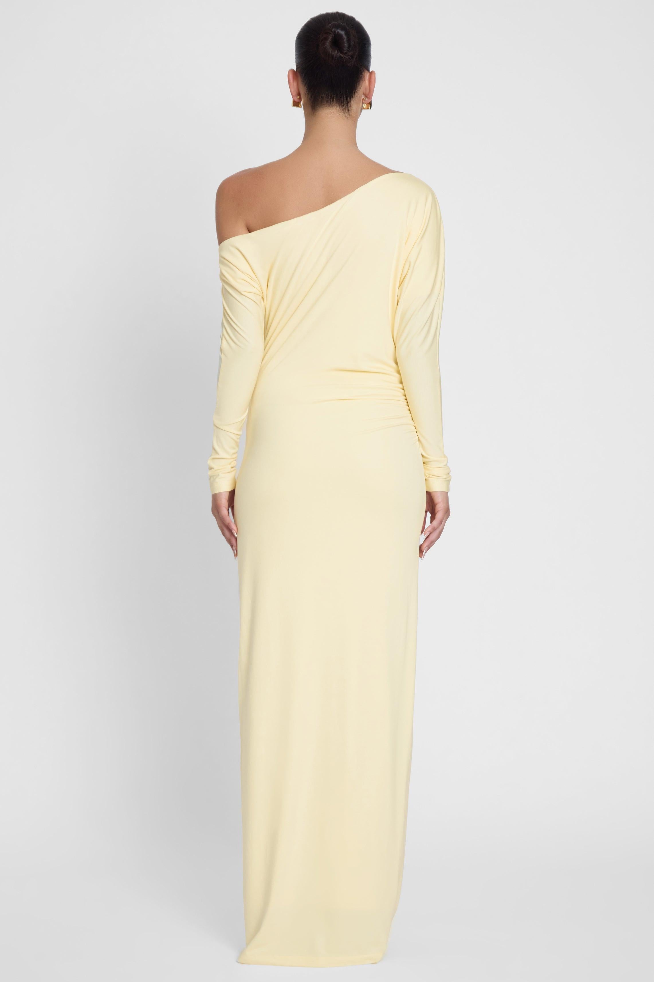 Model is wearing Sola Slouchy Jersey Maxi Dress Yellow, back view.