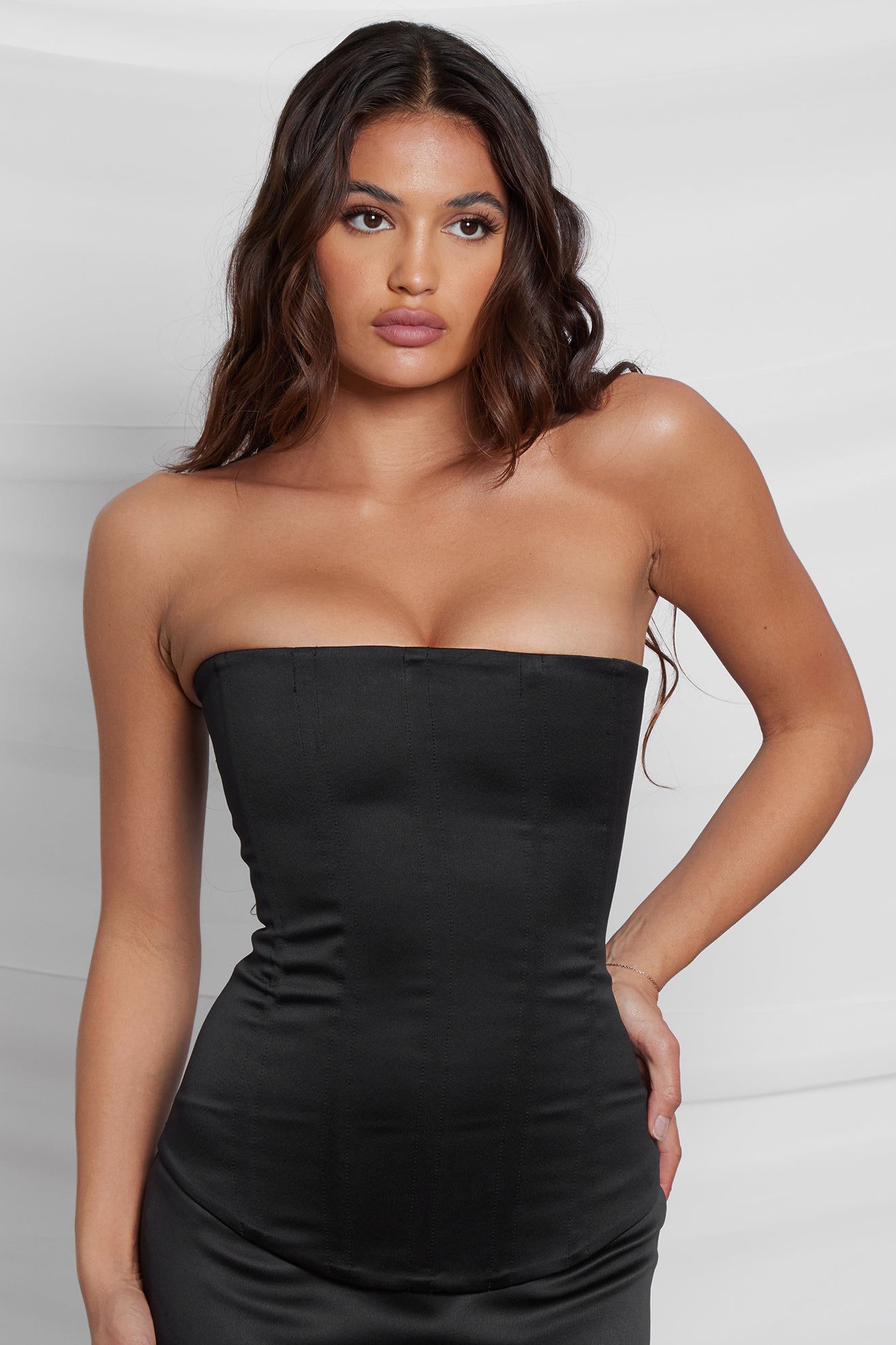 Model wearing Sphynx Satin Corset Top in Black, front view.