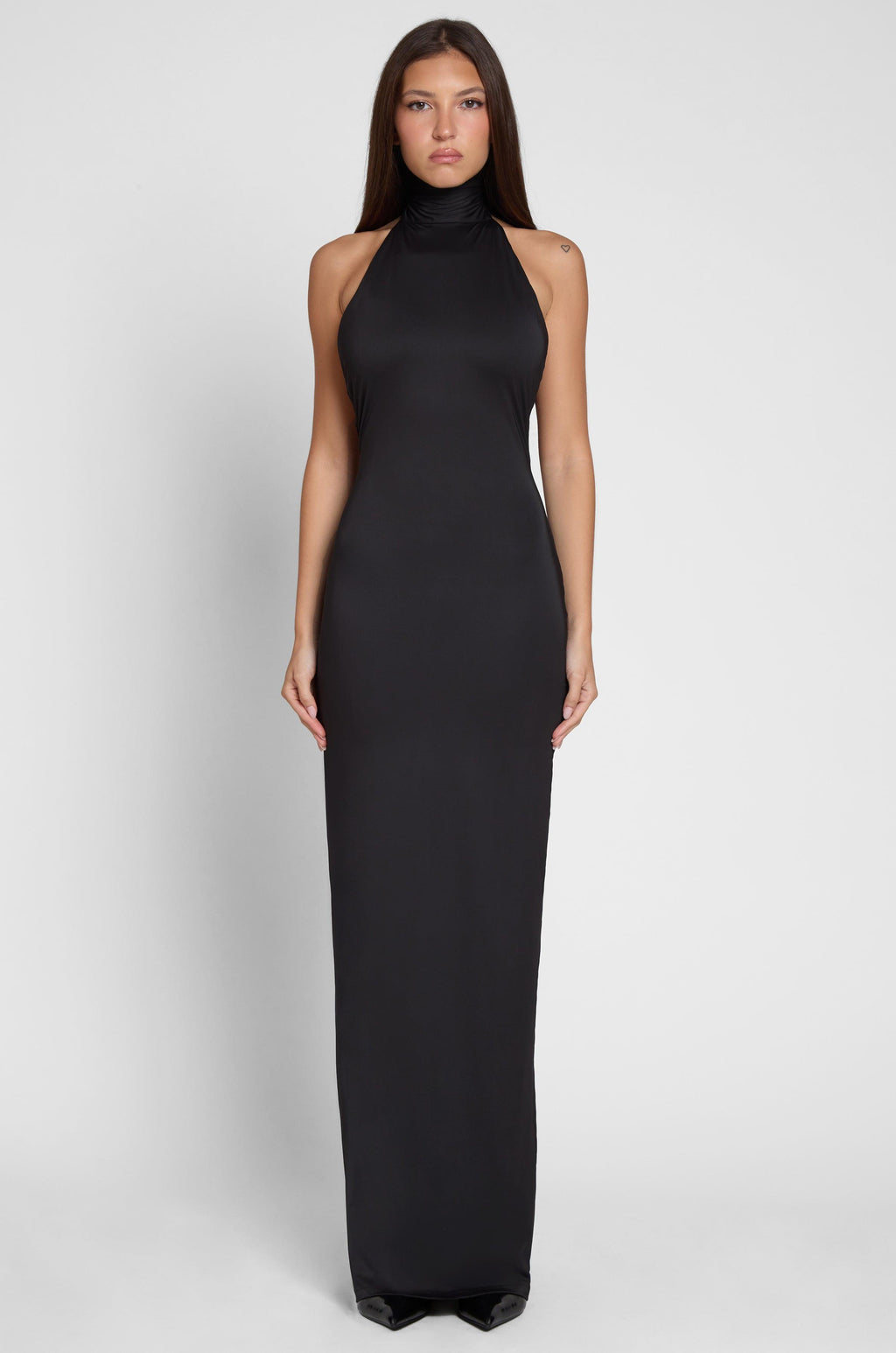 Model is wearing Alaia Drape Maxi Dress Black, front view.