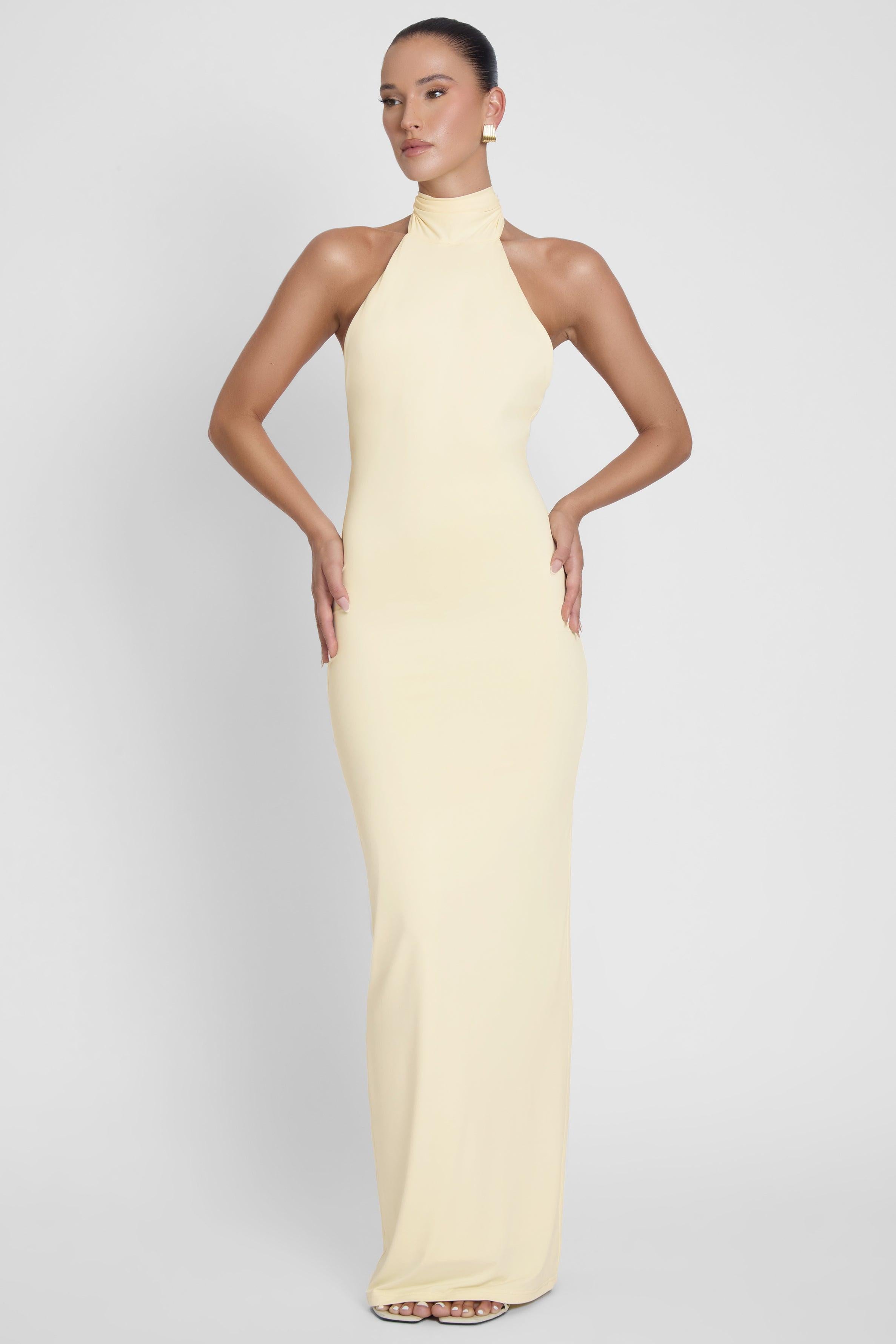 Model is wearing Alaia Drape Maxi Dress Yellow, front view.