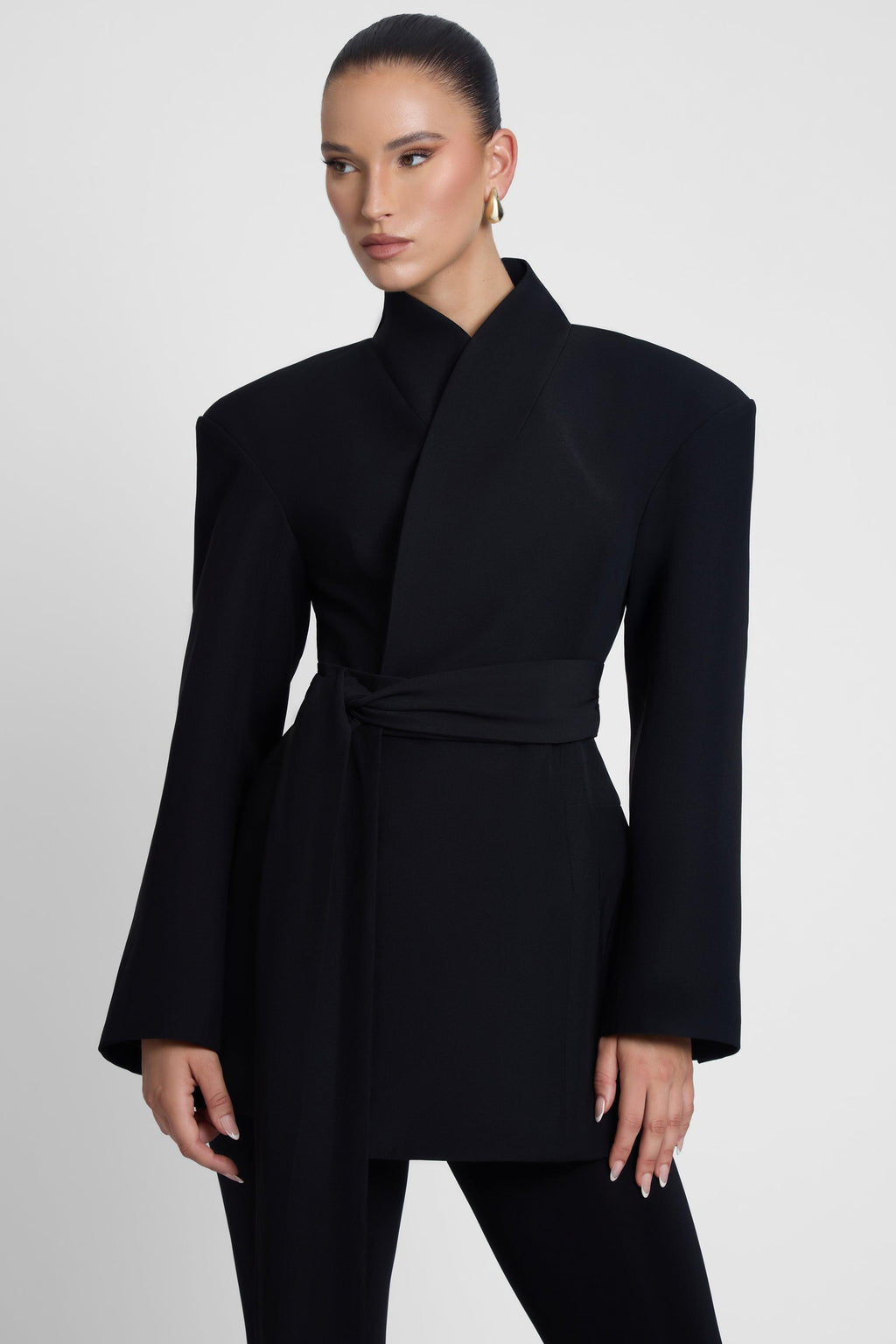 Model is wearing Cairo Hourglass Belted Coat Black, front view.
