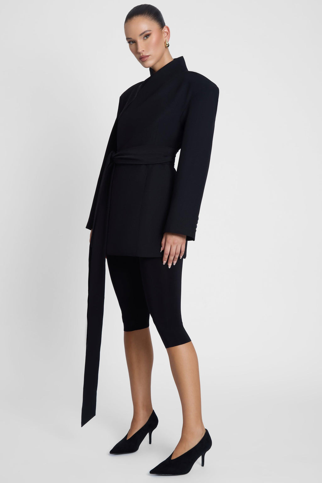 Model is wearing Cairo Hourglass Belted Coat Black, side view.