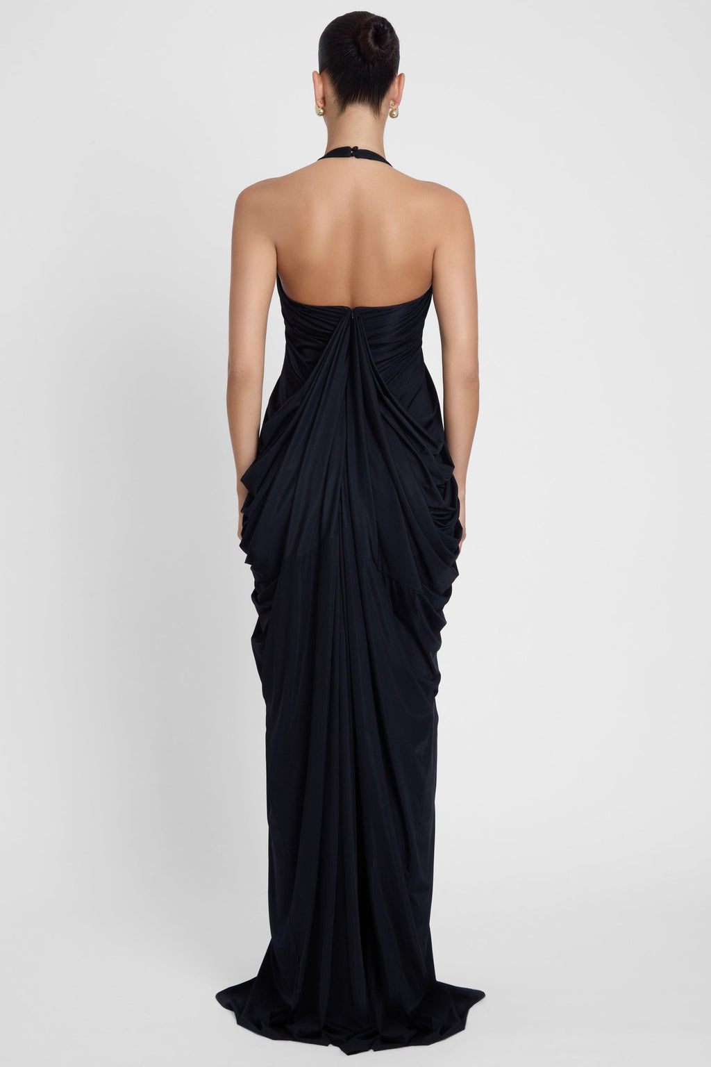 Model is wearing Cascade Drape Gown Black in Black, back view.