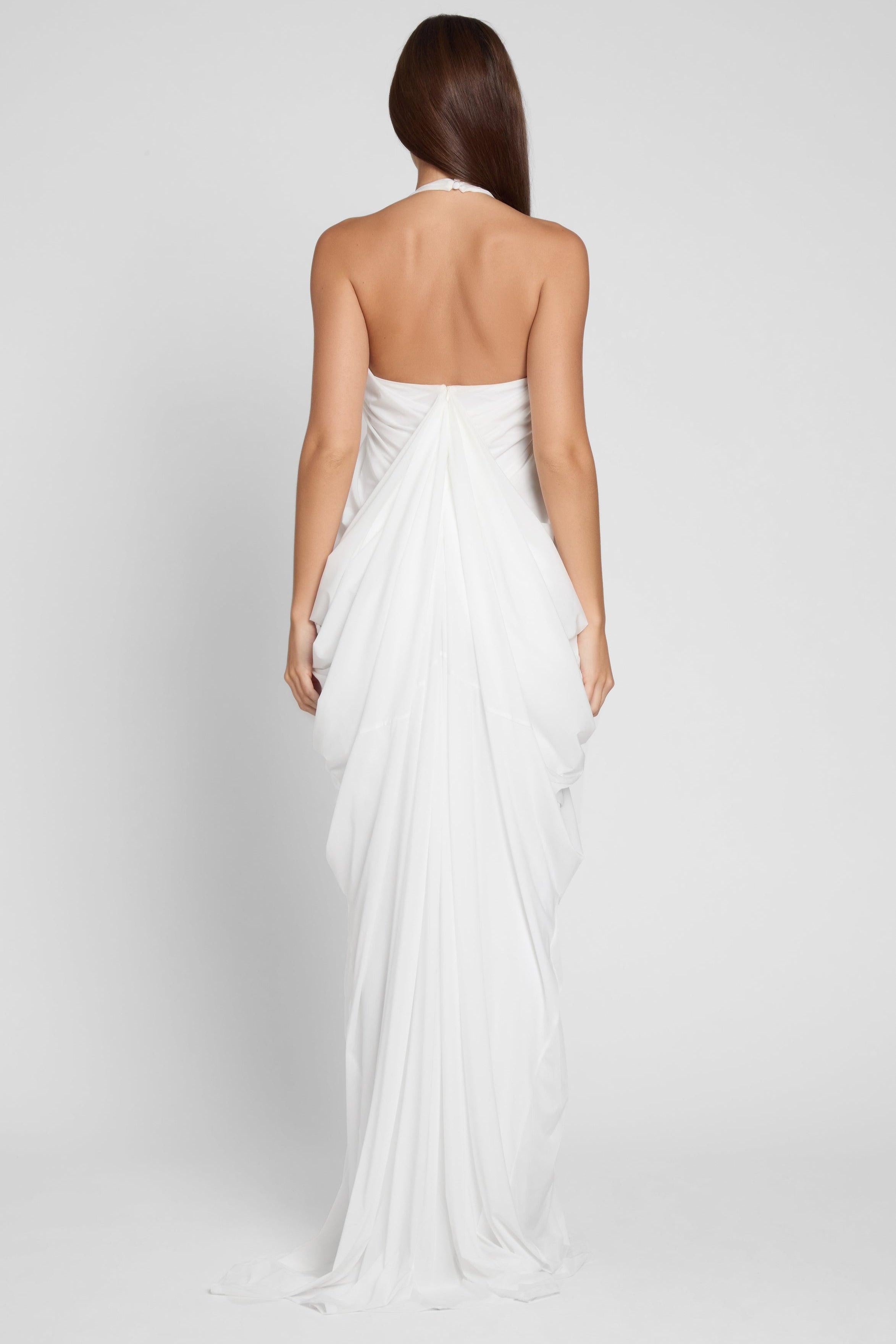 Model is wearing Cascade Drape Gown in White, back view.