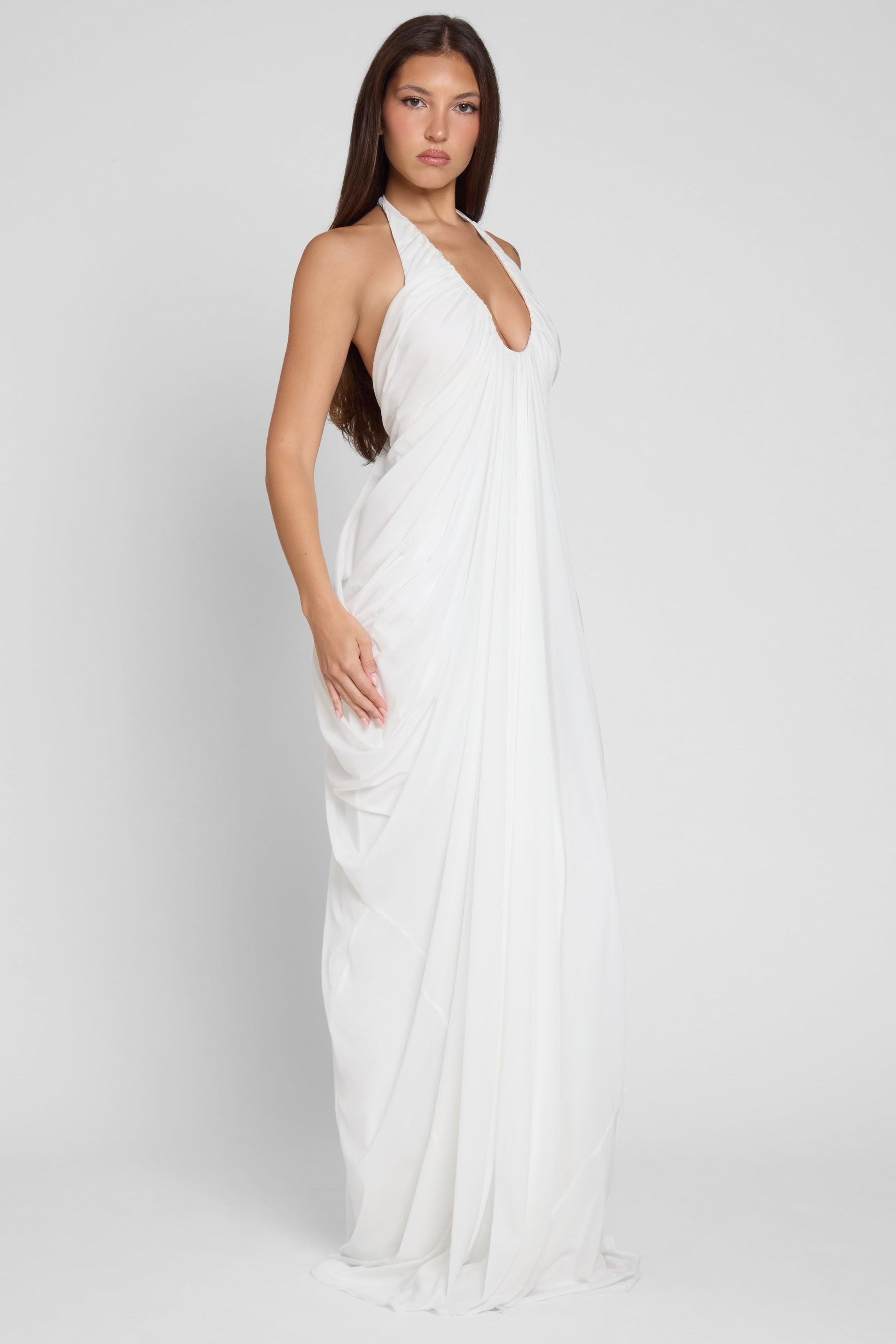 Model is wearing Cascade Drape Gown in White, side view.