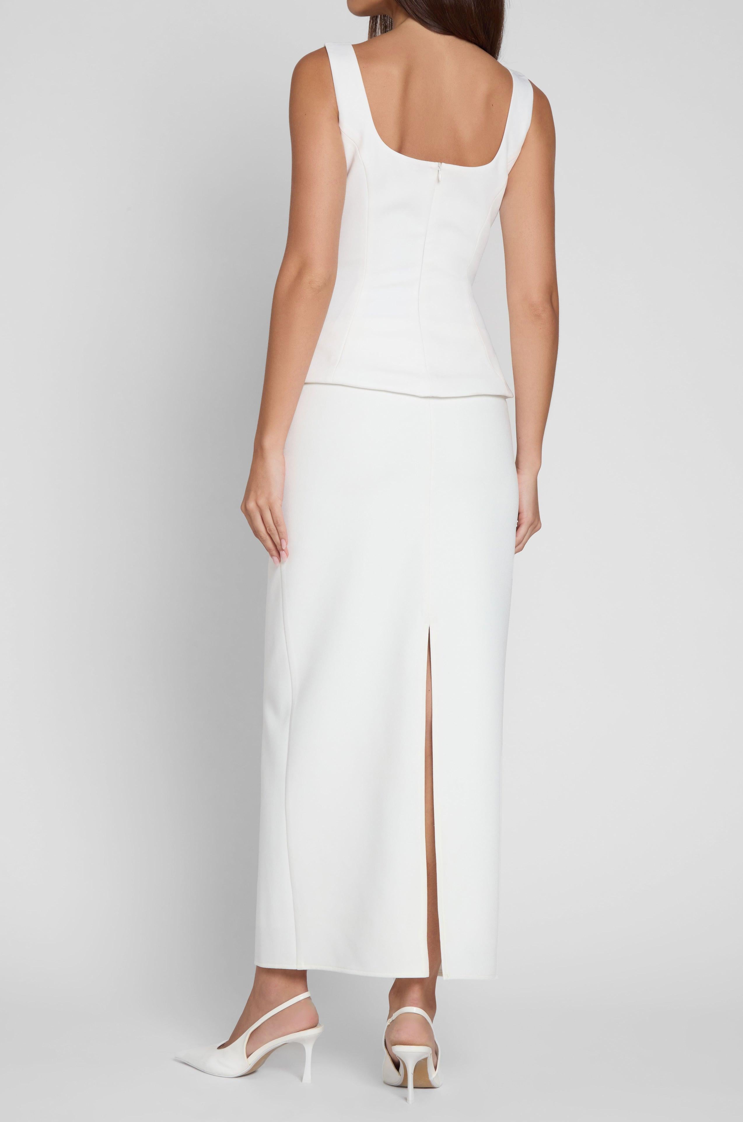 Model is wearing Classic Column Maxi Skirt in White, back view.