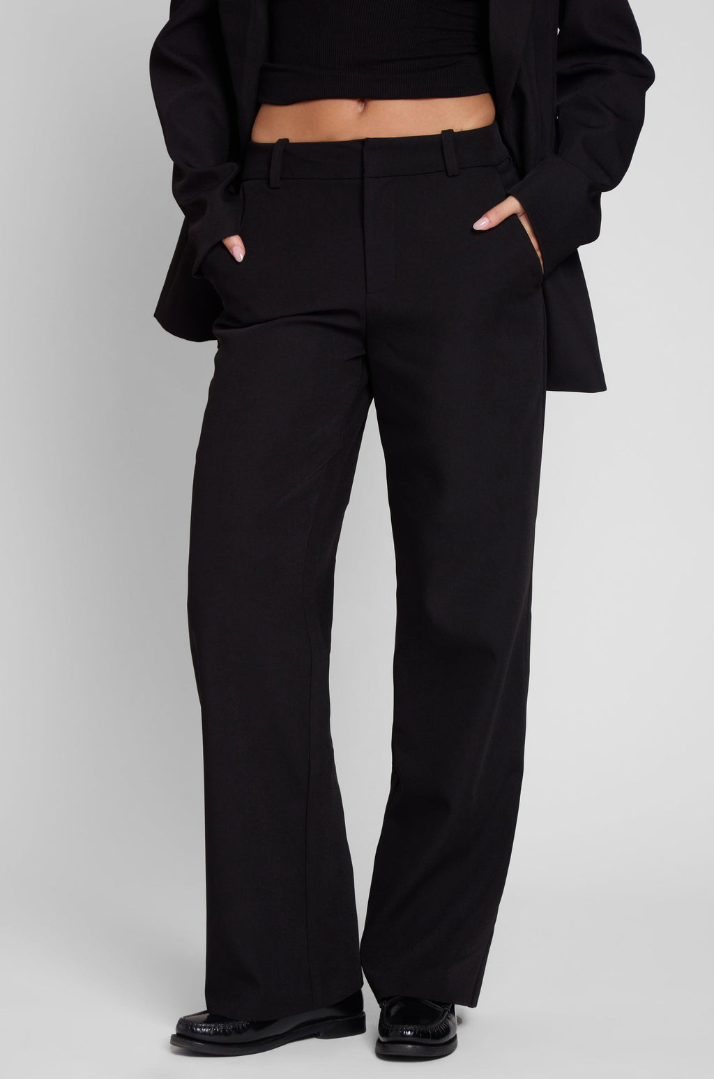 Model is wearing Classic Column Straight Trousers in Black, front view.