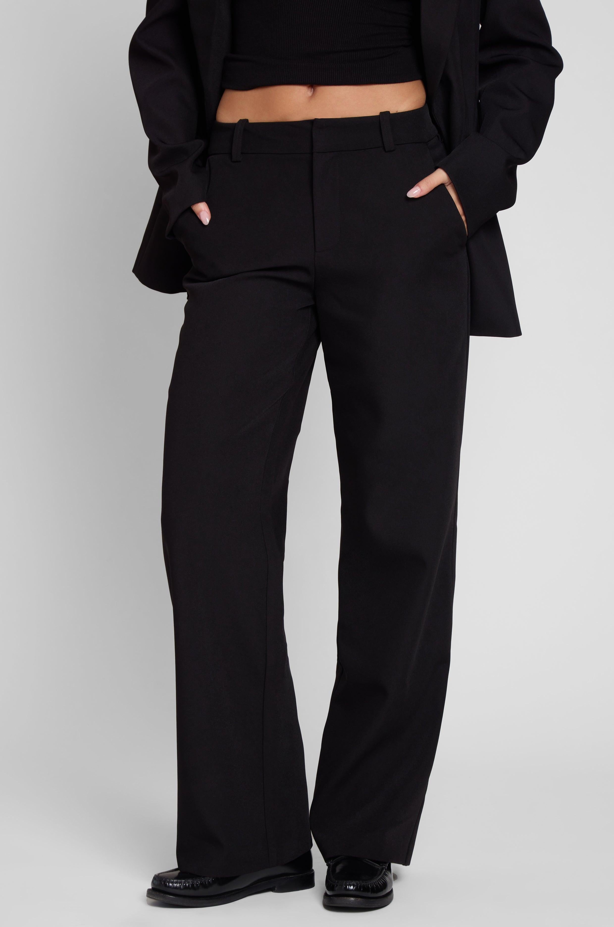 Model is wearing Classic Column Straight Trousers in Black, front view.