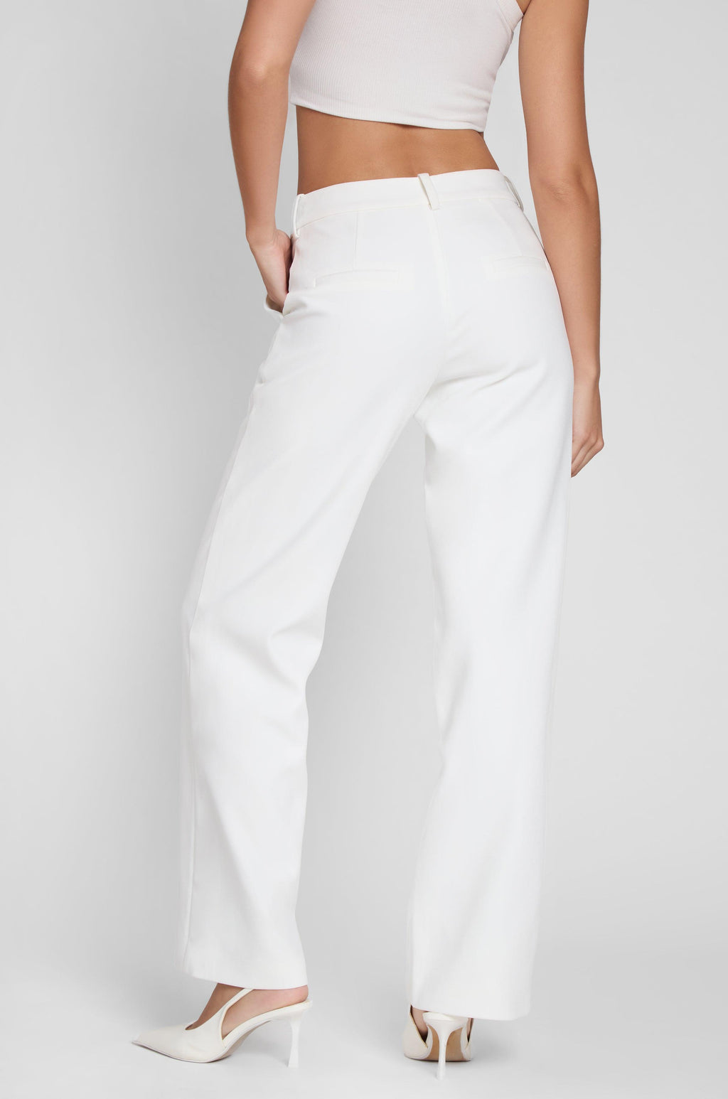 Model wearing Classic Column Straight Trousers in White, back view.