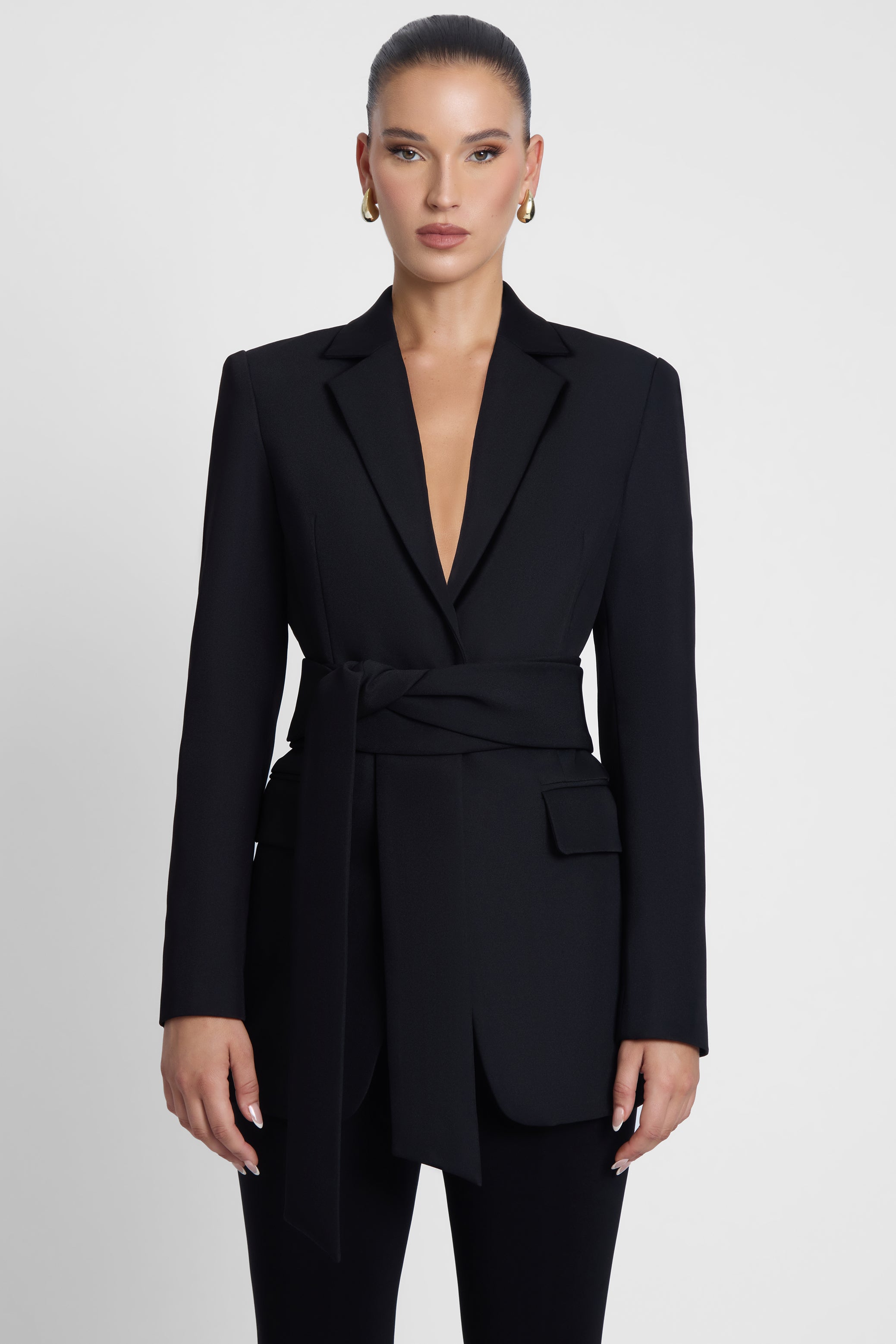 Model is wearing Classic Column Tailored Belted Blazer Black, front view.