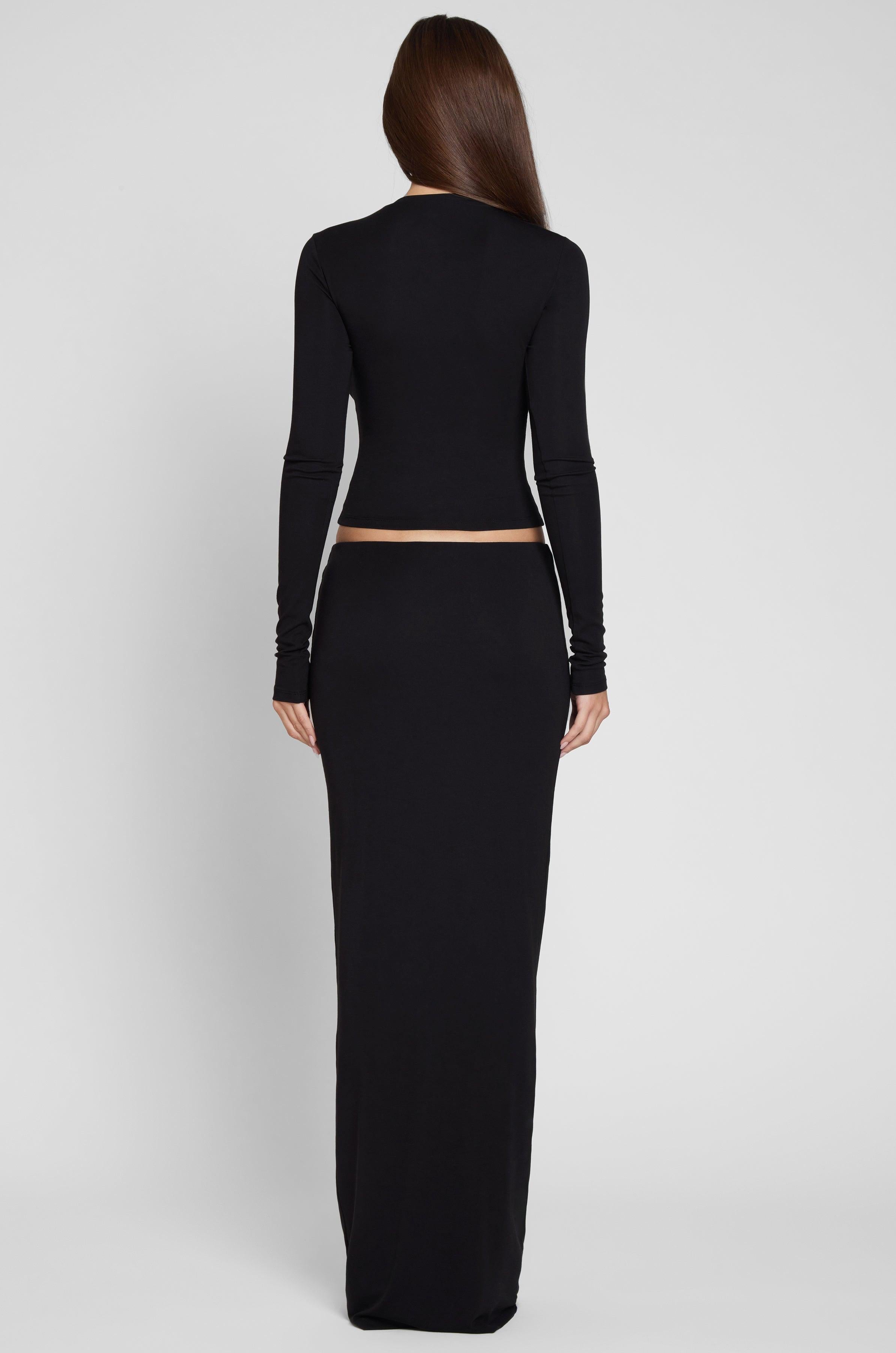 Model is wearing Everyday Jersey Maxi Skirt in Black, back view.