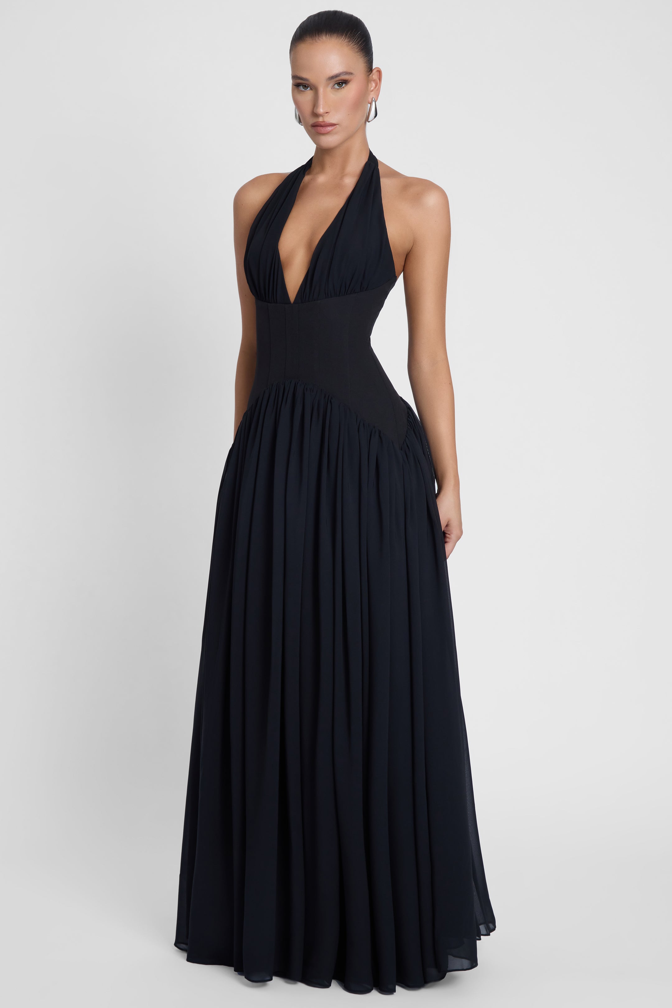 Model is wearing Harlowe Corset Maxi Dress Black, front view.
