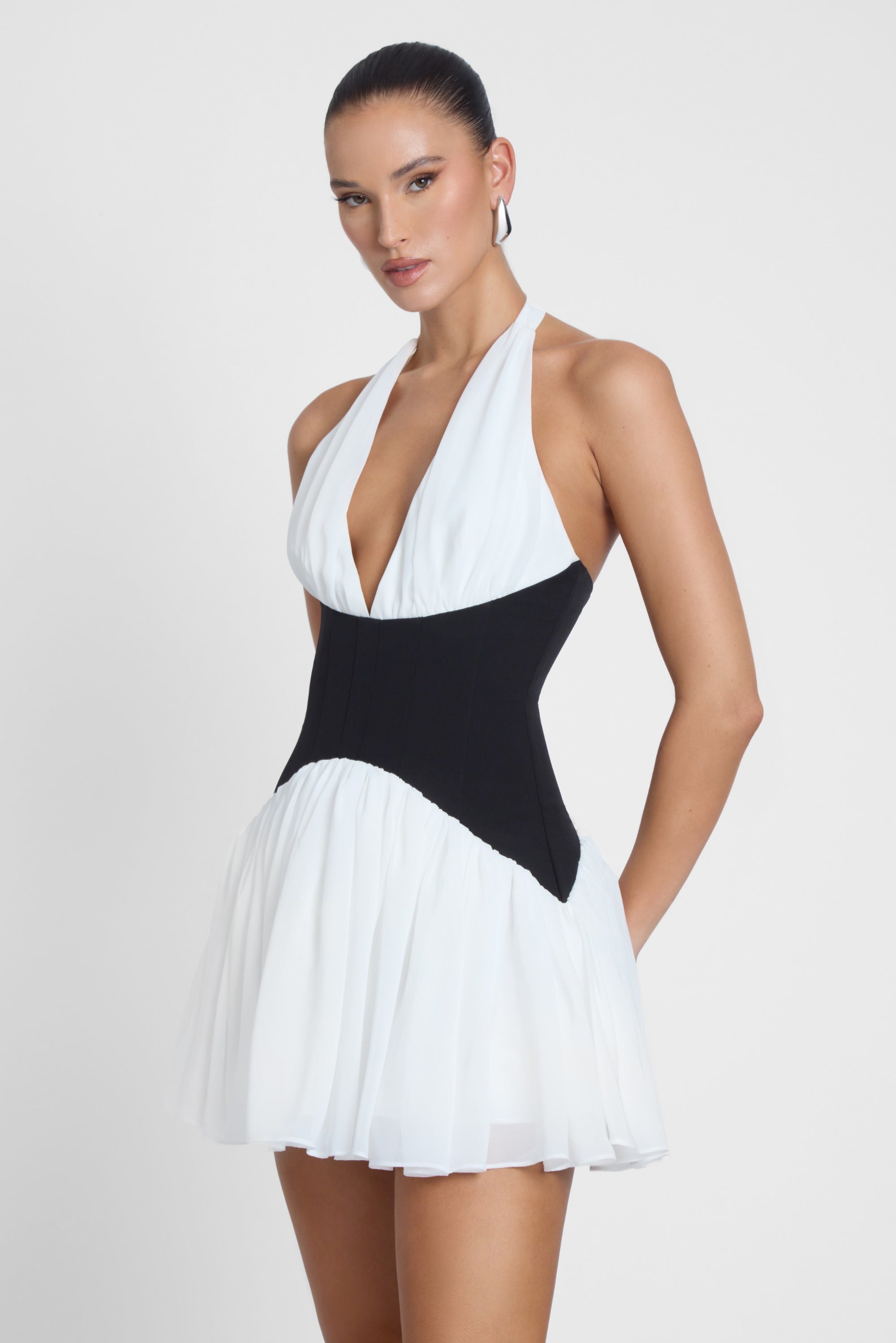 Model is wearing Harper Contrast Corset Mini Dress White, side view.