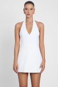 Model is wearing Hera Halter Mini Dress White, front view.