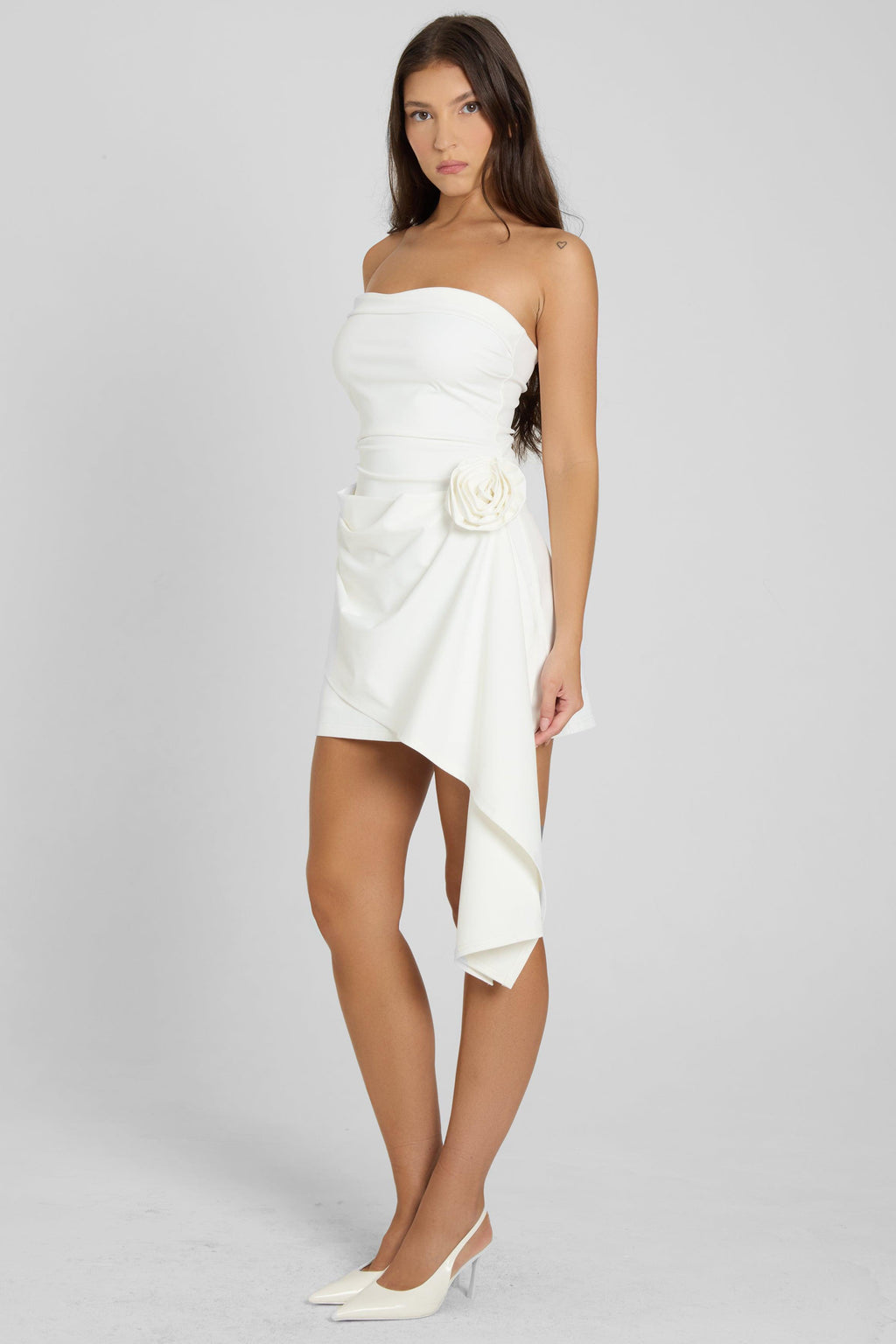 Model wearing Rosette Strapless Mini Dress in White, side view.
