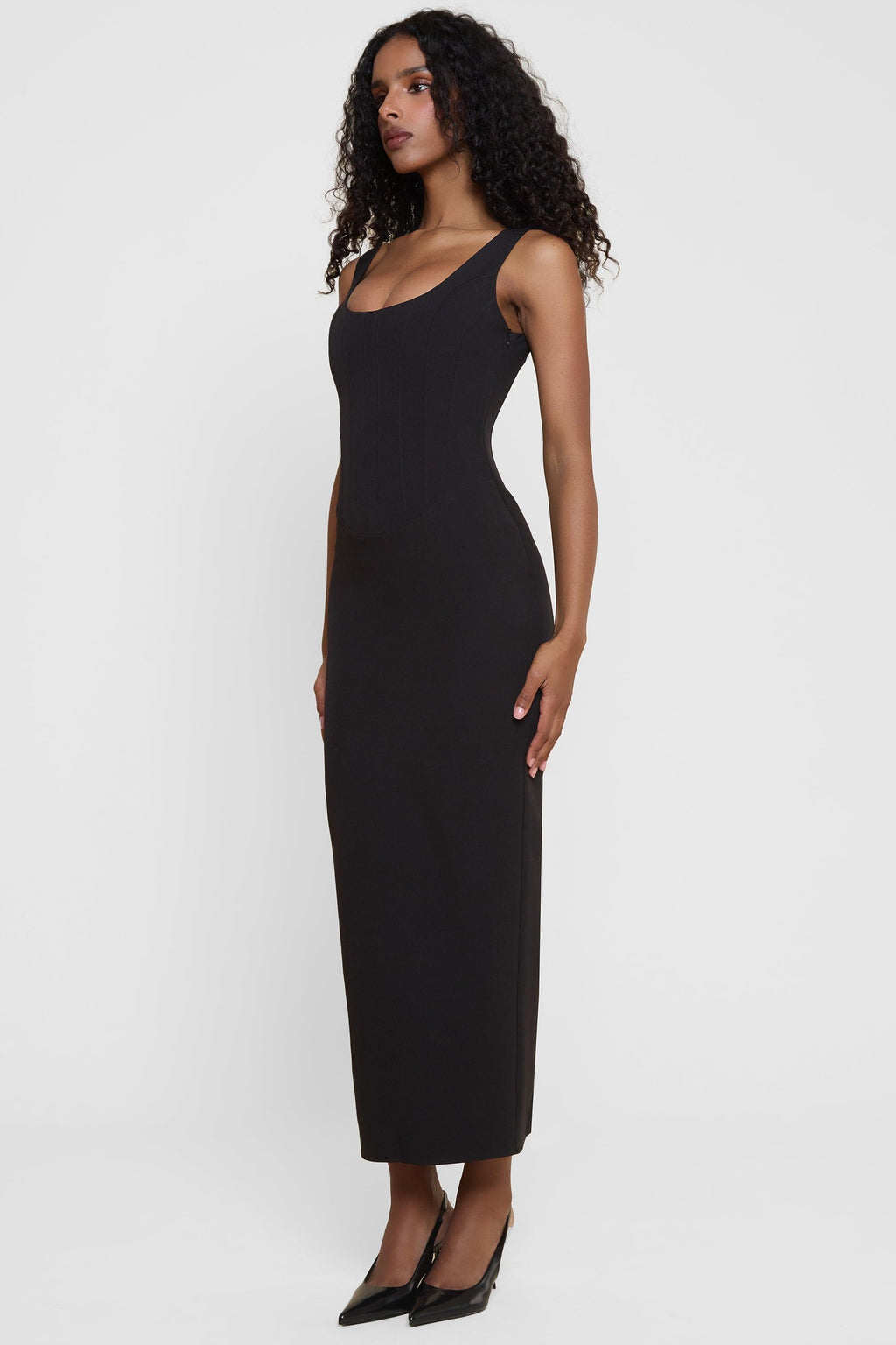 Model wearing Sancia Corset Midi Dress in Black, side view.