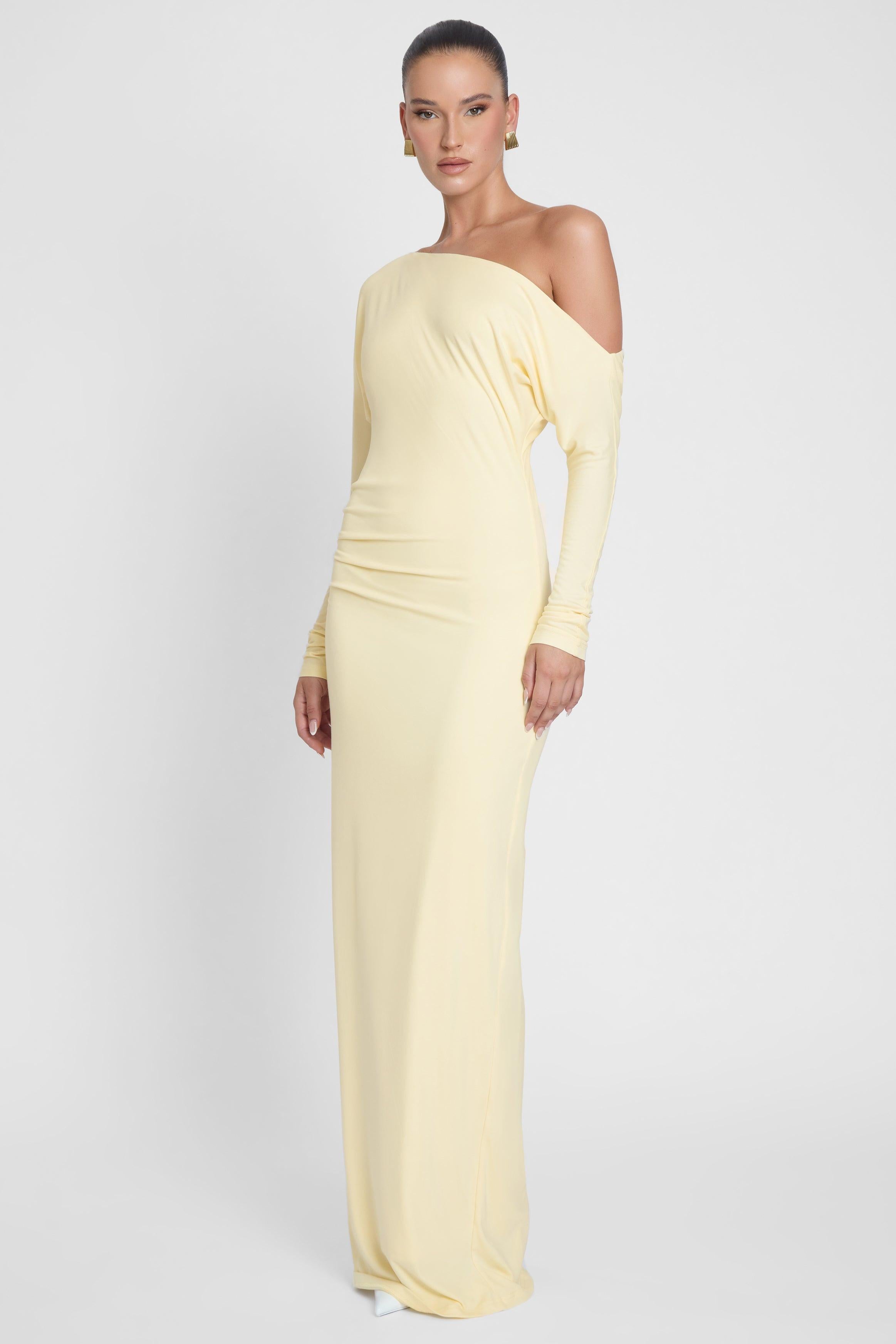 Model is wearing Sola Slouchy Jersey Maxi Dress Yellow, side view.