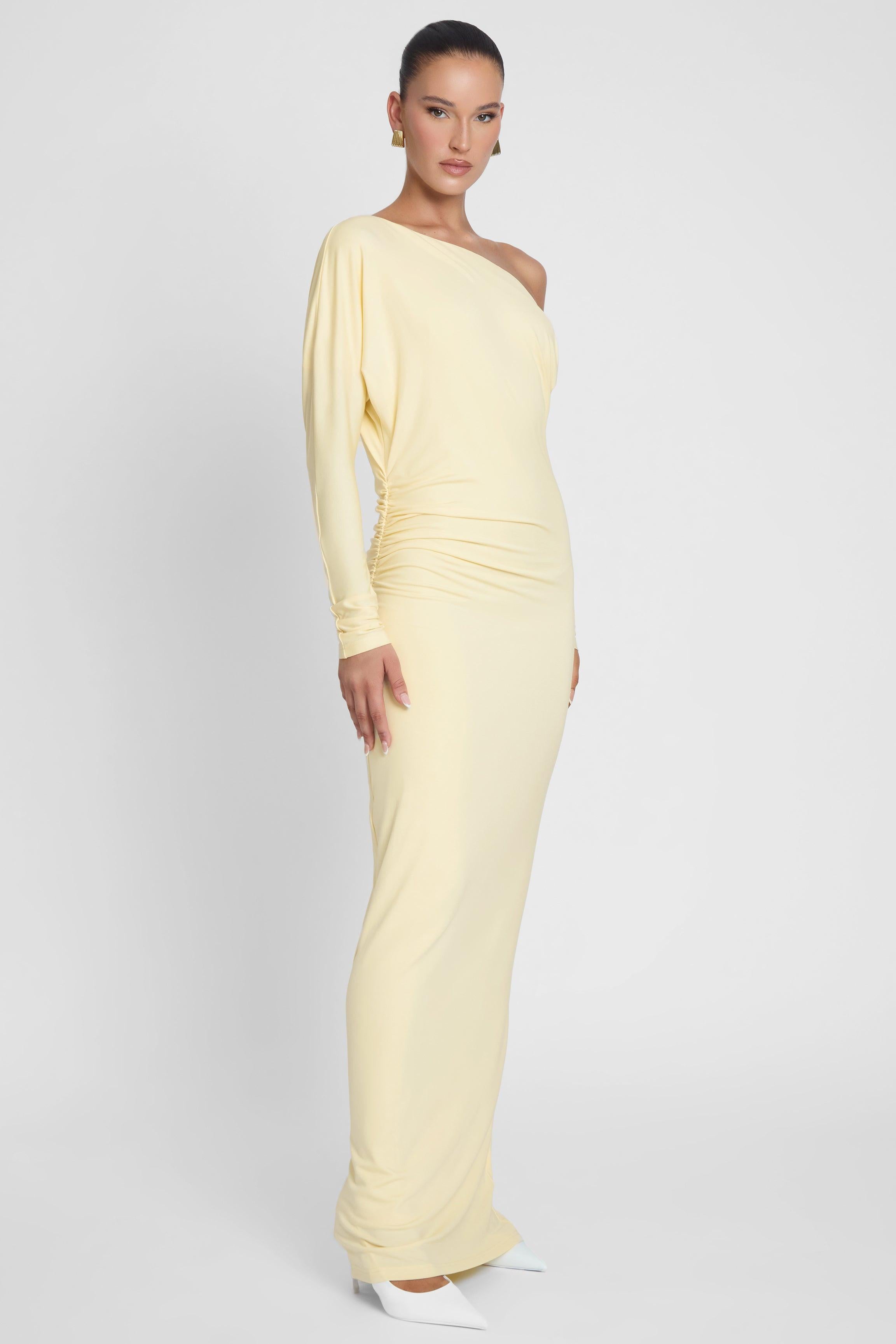 Model is wearing Sola Slouchy Jersey Maxi Dress Yellow, side view.
