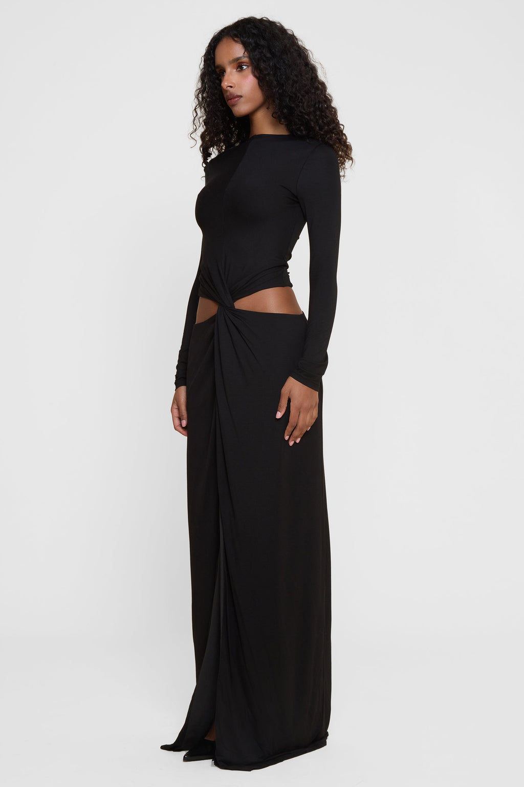 Model wearing Vacanza Drape Gown in Black, side view.